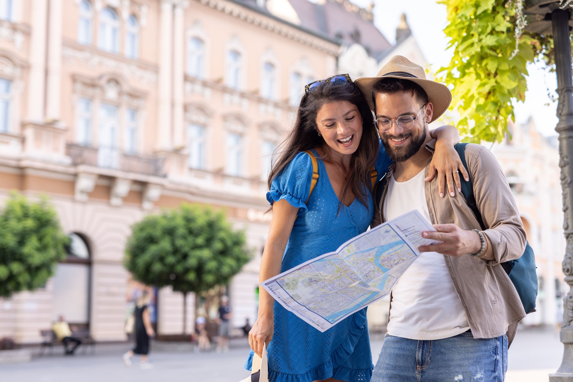 Young couple with a map sharing a laugh on a city adventure