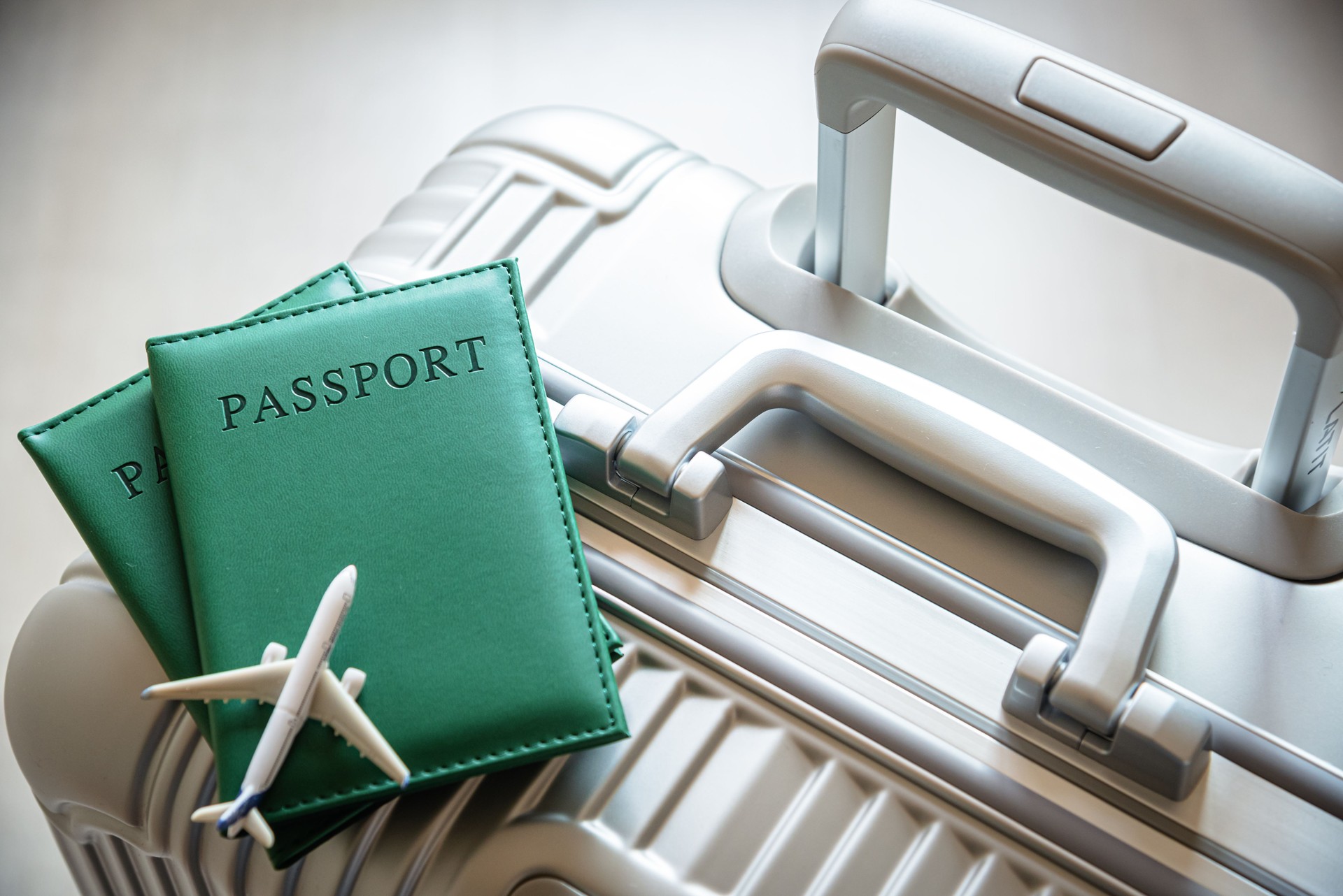 Passports and airplane model on suitcase -- Travel and vacation concept